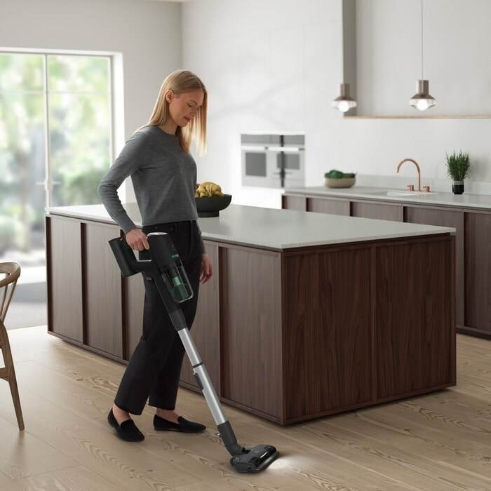 Fatigué femme nettoyer le plancher de la cuisine avec une grosse